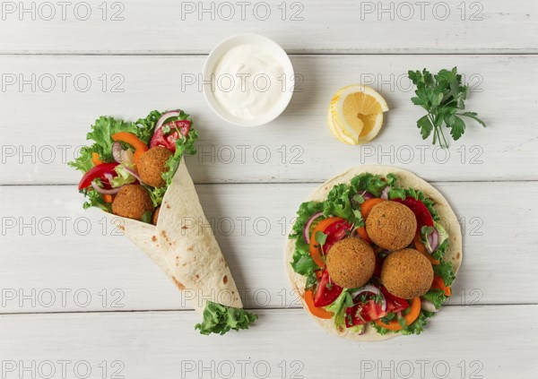 Tortillas, wrapped falafel balls, with fresh vegetables, vegetarian healthy food, on a wooden white