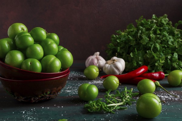 Tkemali, green cherry plum, with ingredients for sauce, cilantro, mint, hot pepper, garlic, on a