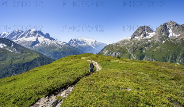 Mountaineer on hiking trail, mountain panorama with glaciated mountain peaks, Aiguille Verte with