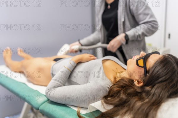 Woman with safety glasses lying comfortable during laser hair removal procedure in a beautician