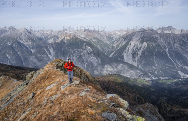 Mountaineer in front of a mountain panorama on a mountain ridge, view from the ridge of the Venet