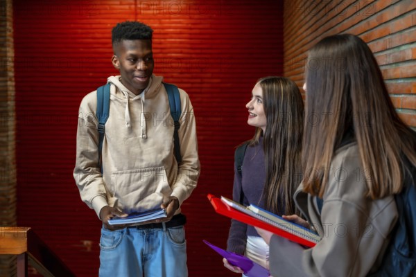 Group of cheerful multi ethnic students talking and smiling together on school hallway during break