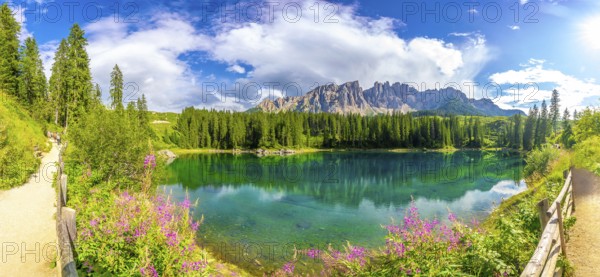 Panoramic view of the beautiful lake carezza with the latemar mountain range in the background on a