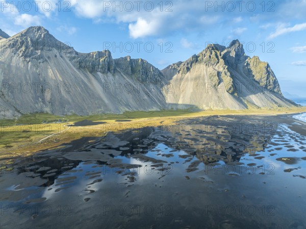 Aerial view of Mt. Vestrahorn, black lava beach, reflections on the water, Stokksnes, east of Höfn,