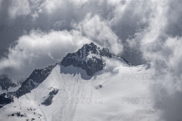 Dramatic clouds, rocky mountain peak with snow and glacier Waxeggkees, Berliner Höhenweg, Zillertal