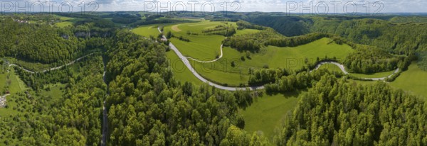 Winding country road through a forest, Swabian Alb in spring, panoramic photo, drone photo,
