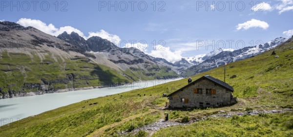 Alpine hut on a blue mountain lake, Lac des Dix reservoir, behind mountain peak Mont Blanc de