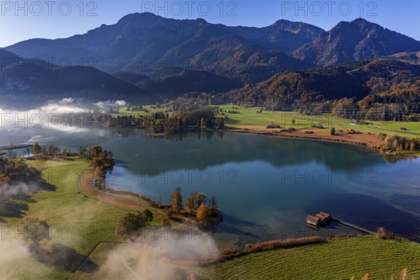 Aerial view of a lake in front of mountains in autumn, midday light, view of Herzogstand and