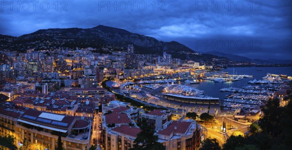 Aerial panorama of Monaco Monte Carlo harbour and illuminated city skyline in the evening blue hour