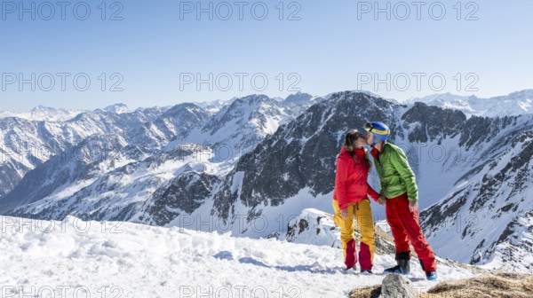 Ski tourer standing next to summit cross, summit of Mitterzeigerkogel in winter, Sellraintal,