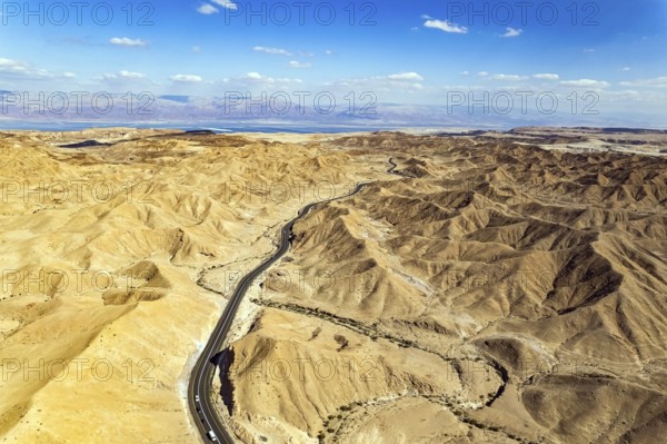 Desert on the shores of the Dead Sea. Asphalt highway meanders among the hills. Dead Sea mud has
