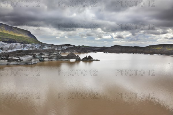 Skaftafell National Park. Ice covered with volcanic ash. Mirror Lake, formed as a result of thawing