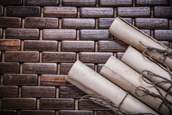 Rolled vintage documents on wicker wooden matting