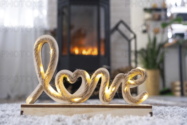 Valentine decor near fireplace stove with fire and firewood. Cozy home hearth in interior with
