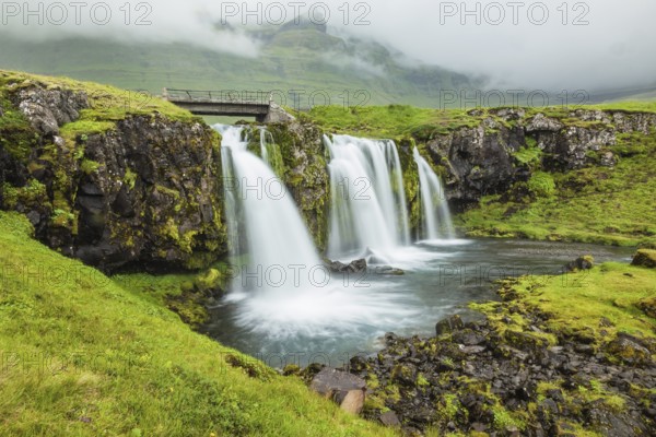 Iceland - country of mountains, rivers and waterfalls. Threaded full-flowing waterfall on the