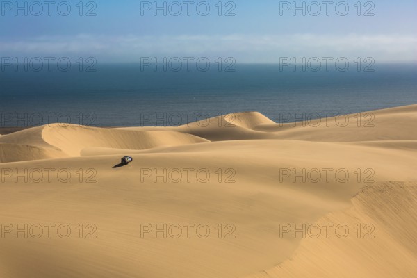 Gorgeous and dangerous jeep - safari through the huge sand dunes on the ocean coast. The concept of