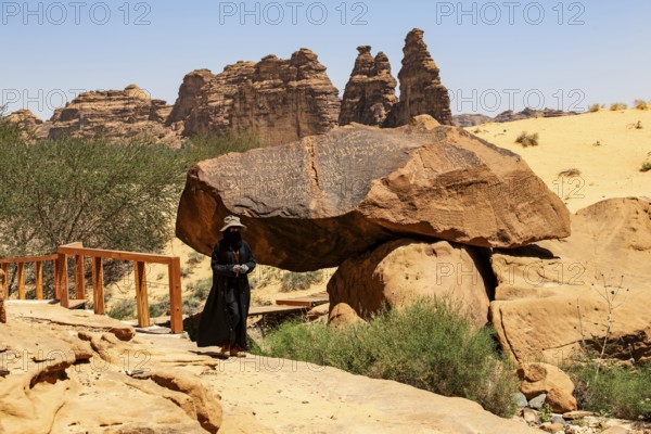Guide in Jebel or Jabal Ikmah shows large open library, rock bands with petroglyphs, rock carvings