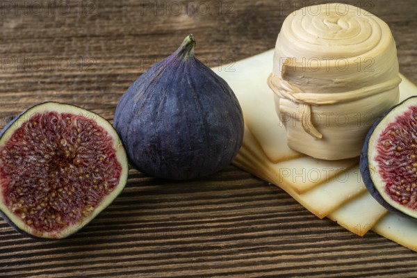 Figs, various cheese on a rustic table.Traditional hand made slovak smoked cheese parenica. Healthy