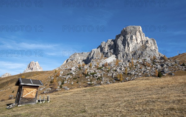 Beautiful mountain landscape with Dolomite rocky peak and a wooden lodge at picturesque Passo Di