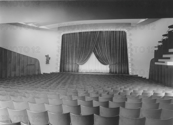 Cinema in the 1940s. An interior of a typical looking movie theatre with seats near the film screen