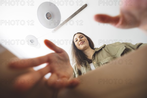 Young caucasian woman receiving a big box of her online orders. Woman opening the package, getting