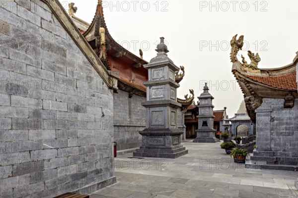 Inner courtyard with grey stone walls in traditional Asian architecture and decorated roofs, The