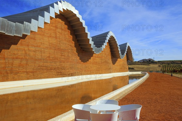 Fragment of the facade is reflected in the pool. Winery - bodega Bodegas Ysios. Journey to the warm