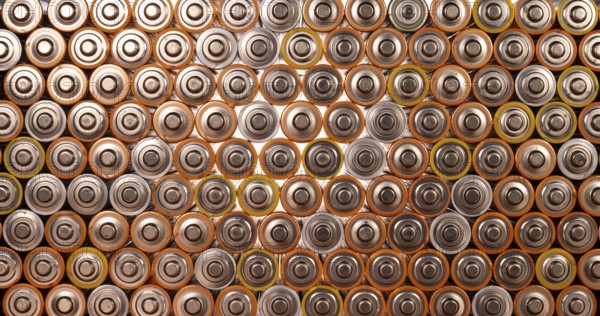 Multiple used AA alkaline batteries are seen arranged in a pile. Closeup front view from the plus