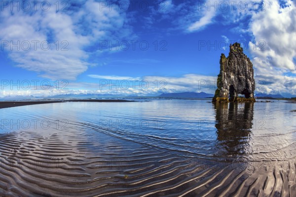 Rock Hvitserkur on the sea beach in the form of a huge elephant. Ocean tide at sunset. The north