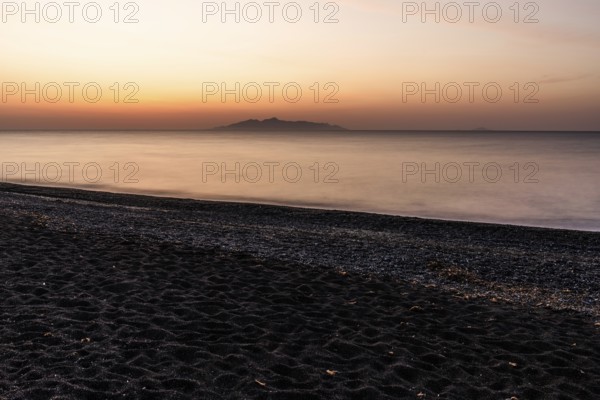 Dawn at sunrise, view from the lava beach near Kamari to the island of Anafi, long exposure, island