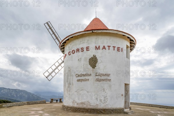 The whitewashed windmill Moulin Mattei with tiled roof and wind vanes at the Col de la Serra of the
