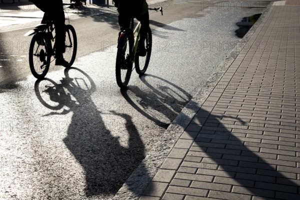 Silhouette of unrecognised people cycling outdoor in the morning. People exercising. Healthy