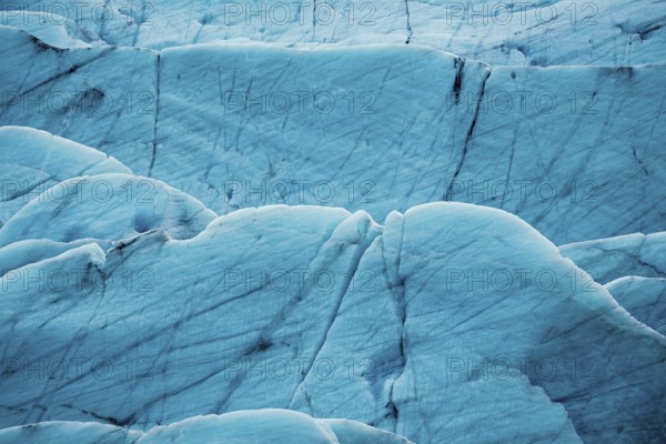 Detailed close-up of a glacier's textured surface with deep blue tones, iceberg, glacier, snow, ice