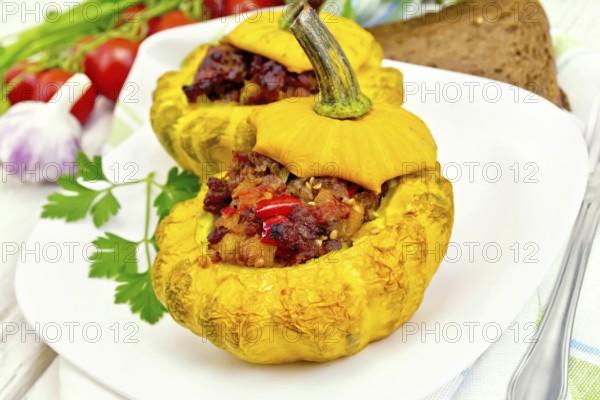 Two yellow squash stuffed with meat, tomatoes and peppers in the dish, bread, garlic, parsley and a
