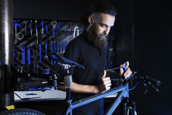 Theme sale and repair of bicycles. Young and stylish with a beard and long hair, a Caucasian man