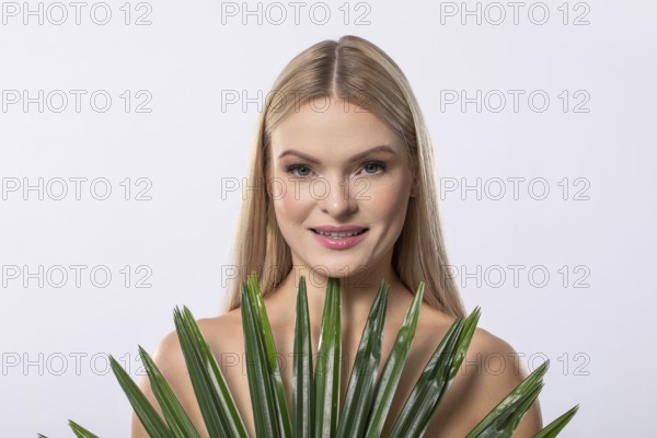 A serene, graceful woman gently cradling a lush aloe vera plant, embodying beauty, wellness, and