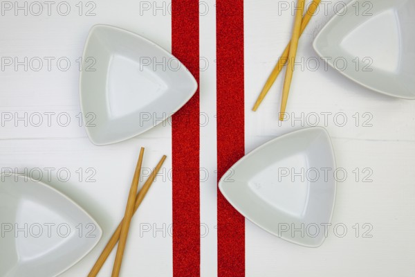 Ceramic bowls and bamboo chopsticks for sushi food with on the white wooden table.Top view. Flat