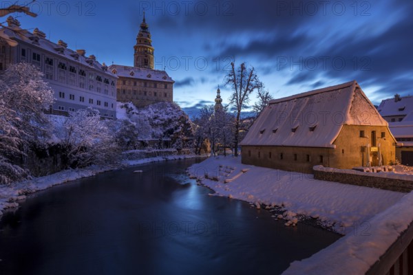 Winter view of Cesky Krumlov, picturesque houses under the castle with snow-covered roofs. Narrow