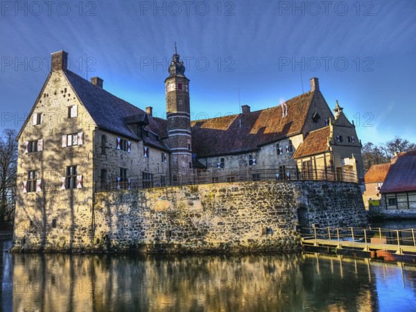 Medieval castle with a moat, shining in the sunlight against a blue sky, Lüdinghausen, münsterland,