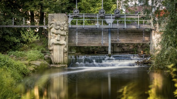 Gundelsheim in Upper Franconia, stream, weir, small bridge with sculpture over a waterfall,