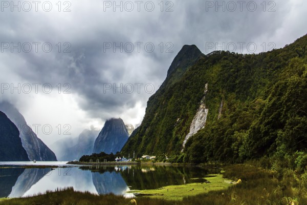 New Zealand. Storm clouds cover the sky over the famous ocean fjord Milford Sound. Port of tourist