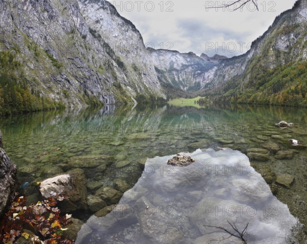 Magic reflection in German lake Koenigssee. Cloudy day on the lake. Clouds and mountains reflected