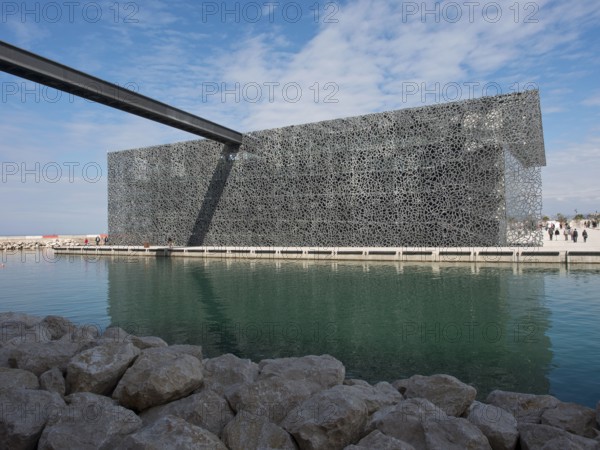 Metal decorated modern building in a watery environment under a blue sky, marseille, mediterranean