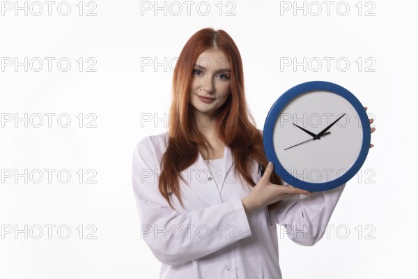 A young woman wearing a lab coat is showcasing a clock, which symbolizes the importance of