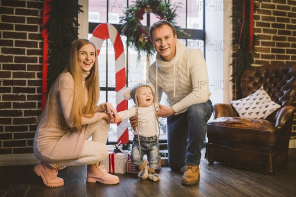 Theme of Christmas holidays and New Year mood. Family posing at home near christmas decor on