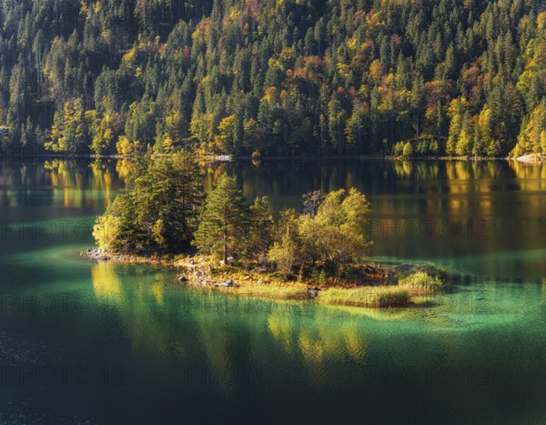 Lake Eibsee with a small island near mountain Zugspitze in south germany in fall