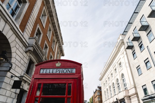 Traditional red telephone box in London, England, UK. Low angle view against sky in Covent Garden