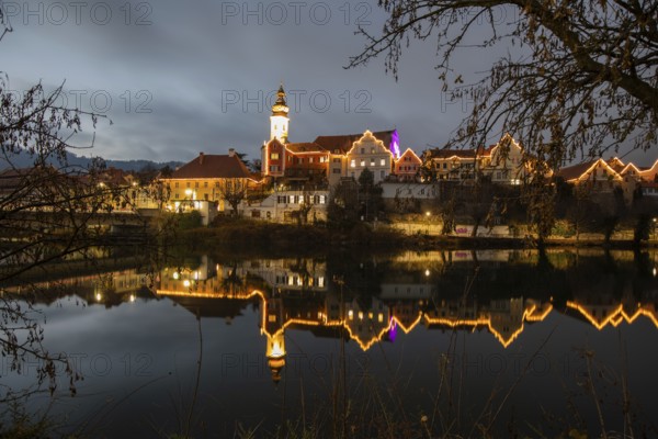 Christmas illuminated house facade of Frohnleiten reflected in the river Mur, Frohnleiten, Styria,