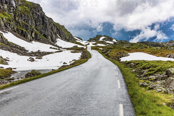 Narrow dangerous mountain road glitters from the rain. Traveling by camper on road 520. Gray rocks