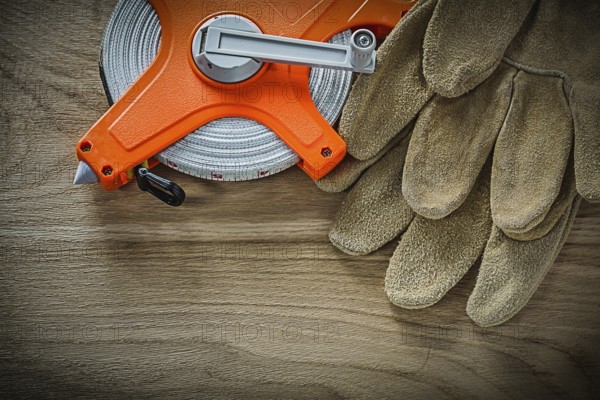 Safety gloves tape measure on wooden board